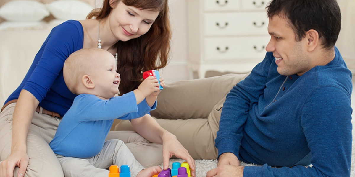 A woman and two men playing with blocks