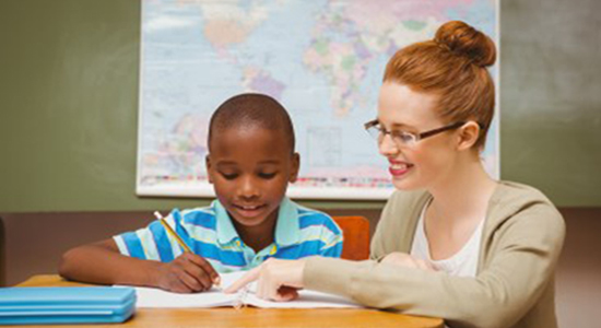 A woman helping a boy with his homework.